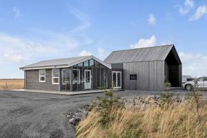 塞尔福斯Selfoss Modern Cabins的一间拥有黑色屋顶和窗户的小房子