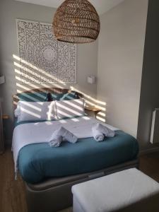 坎佩尔La Petite Perle de Quimper的一间卧室配有一张床,上面有两条毛巾