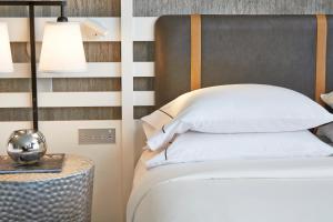 沃思堡沃斯堡沃辛顿万丽酒店的一间卧室配有一张床和一张桌子上的台灯