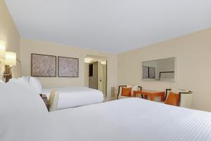 米德兰The H Hotel的酒店客房设有两张床和一张桌子。