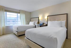 米德兰The H Hotel的酒店客房设有两张床和窗户。