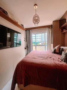 巴西利亚Quarto de Luxo - Saint Moritz的一间卧室设有一张红色大床和窗户