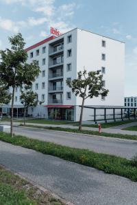 布勒格鲁耶尔布勒宜必思酒店的白色的建筑,旁边有一个红色的标志
