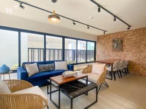 利马Solar by Wynwood House的客厅设有蓝色的沙发和砖墙