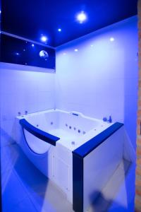 索罗卡巴Lual Motel Sorocaba-SP的白色的浴室设有浴缸和蓝色的天花板。