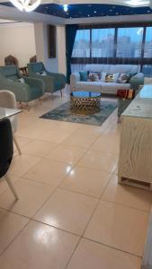 开罗شقة مفروشة للايجار فندقية جنينة مول الرئيسي的大楼内客厅配有沙发和椅子