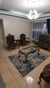 开罗شقة مفروشة للايجار فندقية جنينة مول الرئيسي的客厅配有椅子和茶几