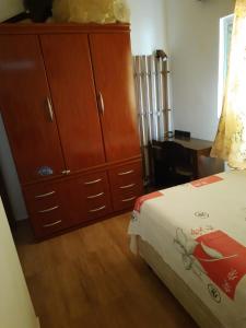 圣若泽杜斯坎普斯Hostel Sancris的一间卧室配有一张床和一个大型木制梳妆台