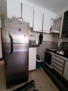 圣若泽杜斯坎普斯Hostel Sancris的厨房配有不锈钢冰箱和炉灶。