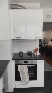 图尔库Central Park Home的厨房配有白色橱柜和炉灶烤箱。
