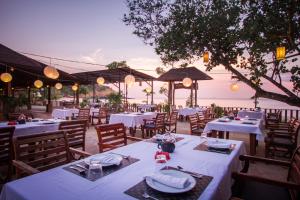 高兰安达兰达度假酒店的一间设有白色桌椅的海洋餐厅