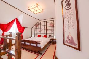 锡吉什瓦拉Casa Lily - Japanese Retreat的一间卧室配有红色窗帘的床