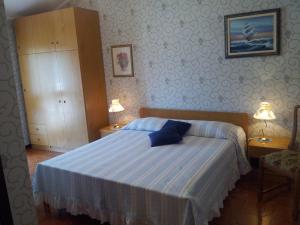 格拉多Meublè Al Ponte的一间卧室配有一张带蓝色床单的床和两盏灯。