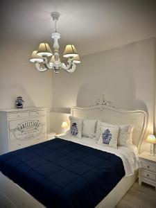 伊斯基亚Maison Mele Ischia的白色卧室配有蓝白色的床和吊灯