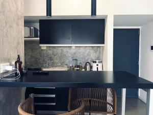 布宜诺斯艾利斯Luxury apartment in Palermo的厨房配有黑色柜台和2把椅子