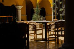 瓦哈卡市Hotel Casona Oaxaca的黄色墙壁的房间的桌椅