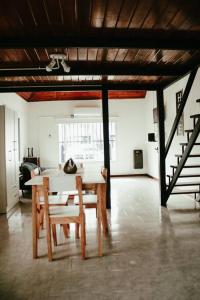 蒂格雷Casa Tipo Loft- Tigre Centro的一间带桌椅和楼梯的用餐室