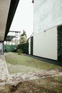 蒂格雷Casa Tipo Loft- Tigre Centro的一座带庭院的建筑旁的白色墙壁