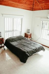 蒂格雷Casa Tipo Loft- Tigre Centro的白色客房的一张床位,设有两个窗户
