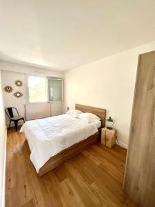 拉罗谢尔Superbe appartement avec parking的一间卧室设有一张大床,铺有木地板