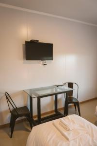 孔奇亚斯HOTEL CONCHILLAS的配有桌子和两把椅子以及电视的房间