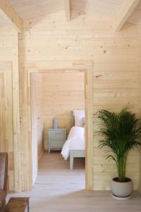 基拉尼Killarney Cabins, Stunning Timber Lodges的木房,配有床和盆栽植物