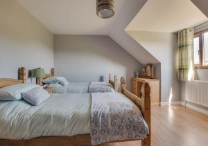 CoelbrenBreconview Lodge的卧室设有2张床和白色的墙壁。