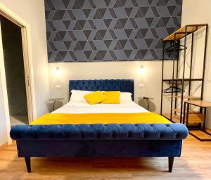 维罗纳Domus 44 Rooms的一间卧室配有一张蓝色的床和黄色的毯子