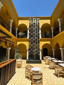 瓦哈卡市Hotel Casona Oaxaca的大楼内带桌椅的庭院