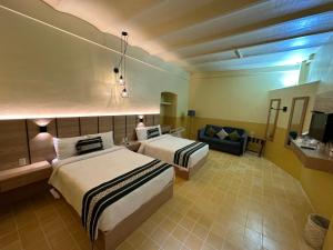 瓦哈卡市Hotel Casona Oaxaca的酒店客房,设有两张床和一张沙发