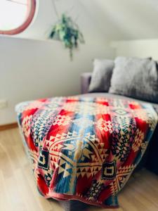 KåsebergaKåseberga Hideout的一张床上有五颜六色的毯子,放在房间里