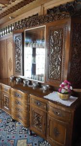 斯利那加Gulbahaar Group Of HouseBoats的一个带镜子和一篮鲜花的木制梳妆台