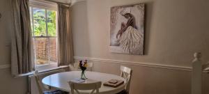 温彻斯特Millstream House的一间饭厅,配有一张桌子和一张女人的照片