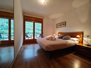 坎普罗东Allotjaments Bruc的卧室配有一张大床、木地板和窗户。