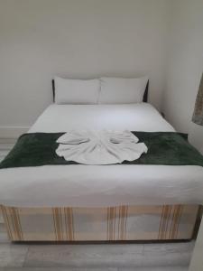 伦敦W3 Guest House的卧室配有一张带绿毯的白色床