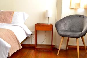 阿雷基帕Maison verte - Guest House的卧室配有床边的椅子