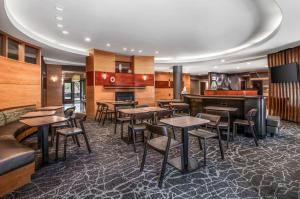 格伦代尔SpringHill Suites Phoenix Glendale Sports & Entertainment District的一间带桌椅的餐厅和一间酒吧