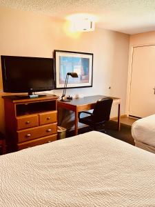 劳埃德明斯特劳埃德明斯特皇家酒店的酒店客房配有一张书桌、一台电视和一张床