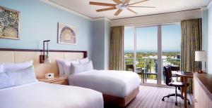 迈阿密The Ritz Carlton Key Biscayne, Miami的酒店客房设有两张床、一张书桌和一个窗户。