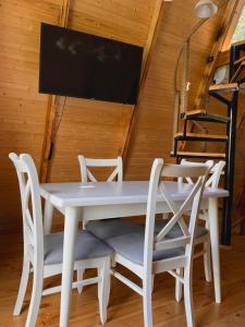 K'edaHillSide Cottage的白色的餐桌、椅子和平面电视