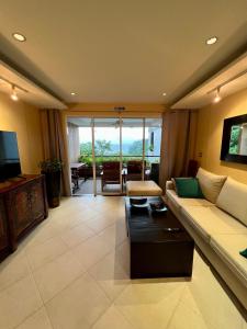 卡塔海滩Luxury Apartment Kata Beach The Accenta的客厅配有沙发和桌子