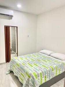 蒙特里亚Bonito Apartamento Monteria的一间卧室配有一张带绿色和白色棉被的床