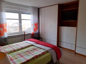 不来梅港Ferienwohnung AMBIENTE的一间卧室设有一张床、一台电视和一个窗口。