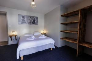 阿尔维厄la casse deserte的一间卧室配有带白色床单和架子的床