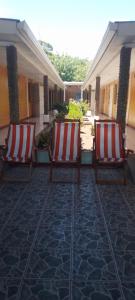 Santo DomingoHostal Miraflores B&B的两把红色和白色的椅子坐在庭院里