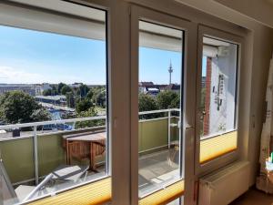 不来梅港Ferienwohnung AMBIENTE的阳台设有2扇窗户和桌椅