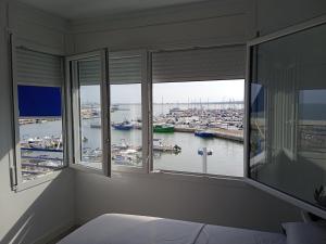 安波拉Vora Port的一间卧室设有窗户,享有海港景色