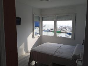 安波拉Vora Port的一间卧室设有两个窗户,享有海港景色