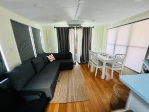 萨拉索塔Sunshine Tiny Home Pinecraft的客厅配有黑色沙发和桌子