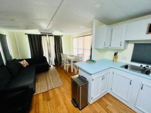 萨拉索塔Sunshine Tiny Home Pinecraft的厨房以及带沙发和桌子的客厅。